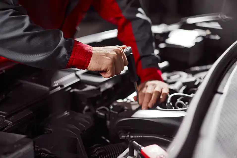 Mechaniker bei der Arbeit am Motor in der eigenen Werkstatt
