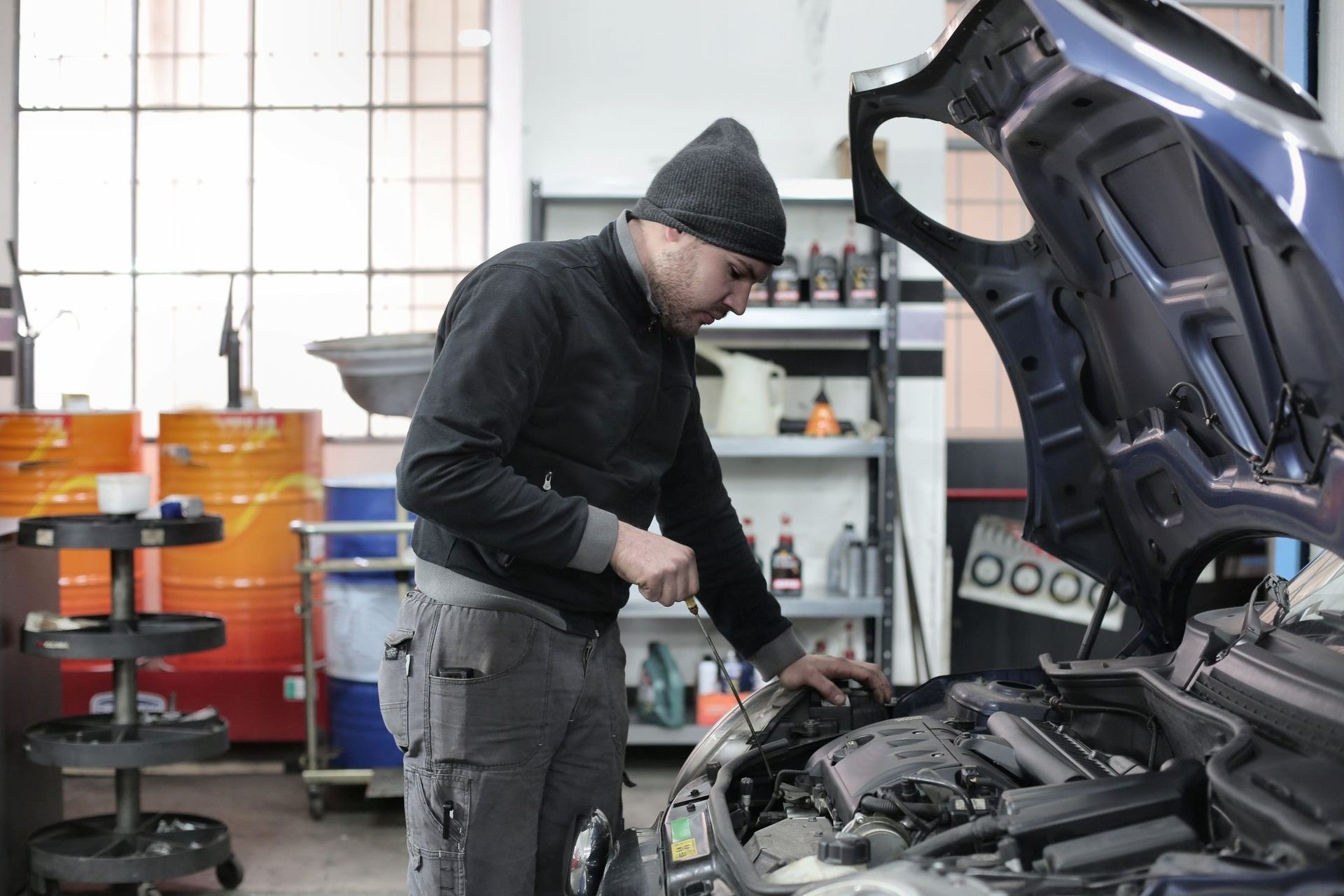 Mechaniker bei der Arbeit unter der geöffneten Motorhaube